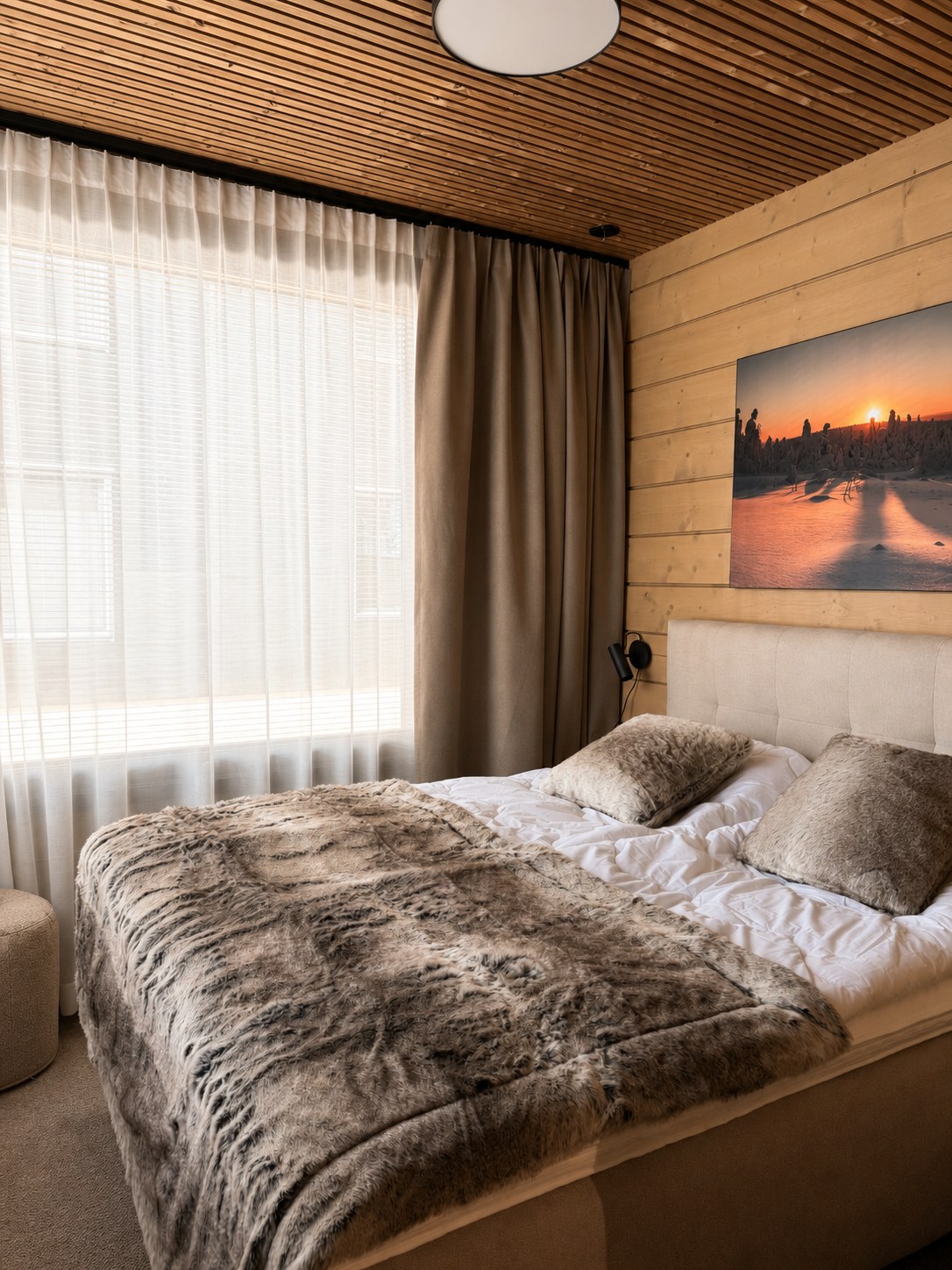 Woonkamer met bank, fauteuil en boszicht