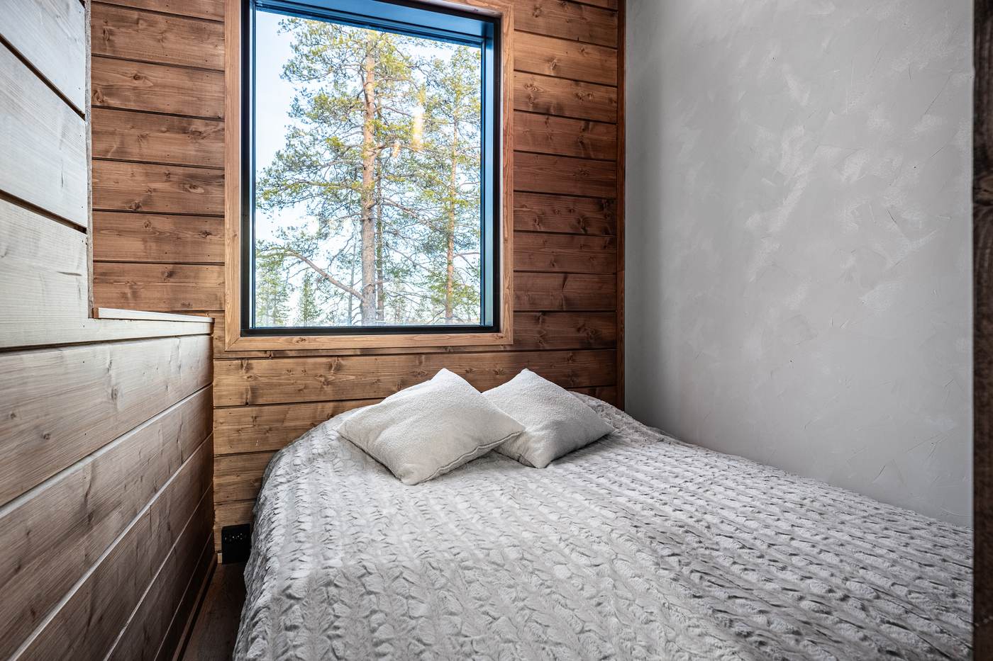Bedroom with a large window onto the pines