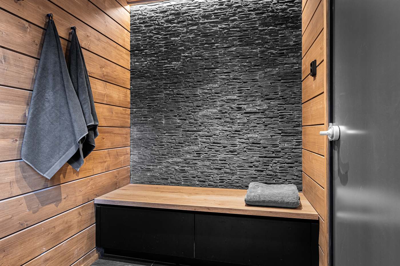 Sauna changing room with stone wall and towels