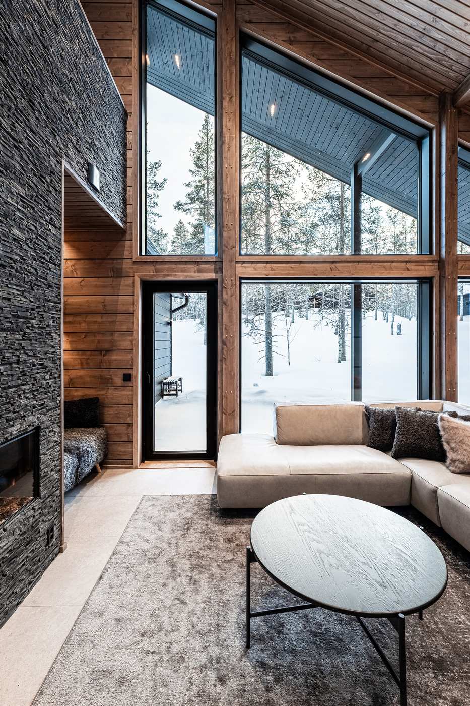 Living room with fireplace, tall windows and leather sofa