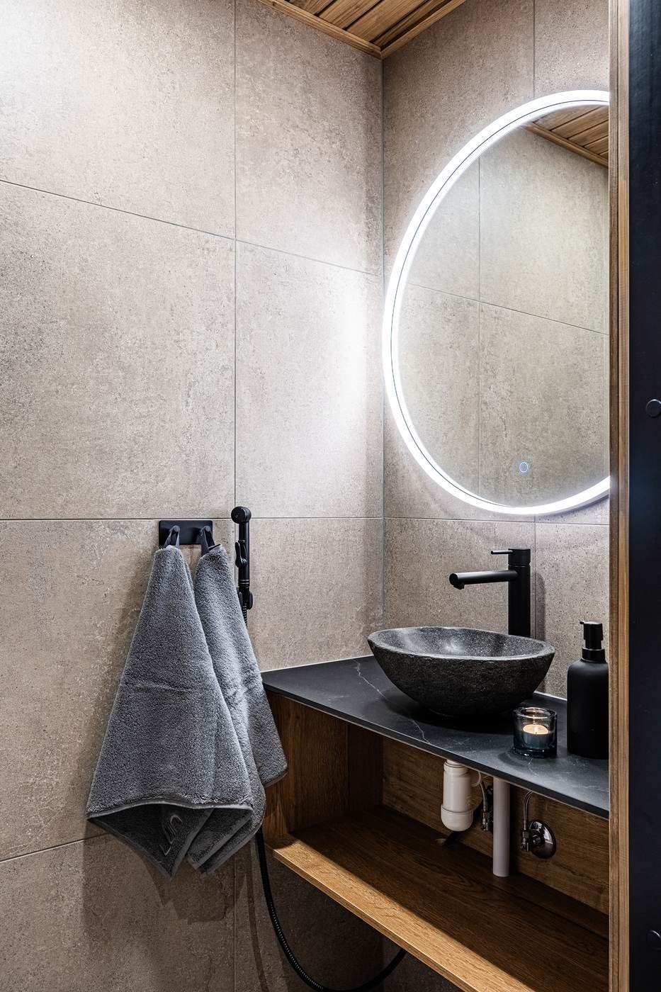 Bathroom with stone basin and illuminated mirror