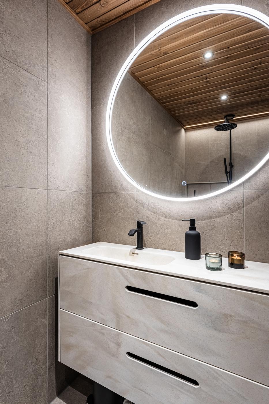 Bathroom with vanity, round mirror and rain shower